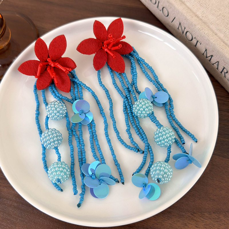 أقراط طويلة بخرز أزرق وزهرة حمراء